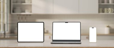 Beyaz mermer mutfak masasında üç adet boş ekran ve bulanık beyaz mutfak..