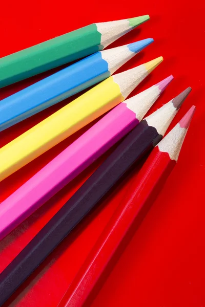 赤の背景に複数の色の鉛筆 — ストック写真