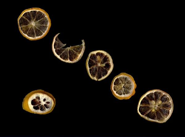 Сушеный (сушеный) лимон крупным планом на черном фоне — стоковое фото