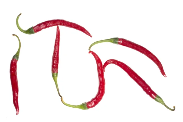 Фигура, выложенная из плодов красного перца на белом фоне — стоковое фото