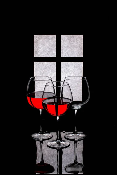 Stillleben Mit Gläsern Und Rotwein Vor Dem Hintergrund Einer Fenstersilhouette — Stockfoto