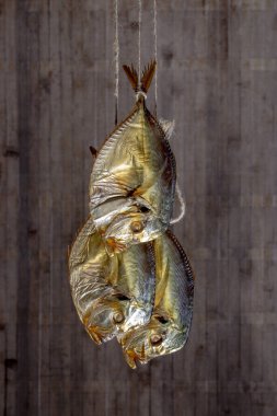Tütsülenmiş üç deniz balığı Bencilce bir ip üzerinde yakın plan