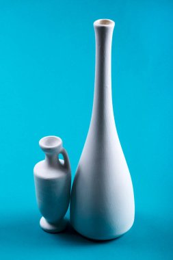 Mavi arka planda beyaz vazolarla hayat