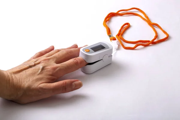 パルス酸素濃度計の心拍数と酸素飽和度を測定しながら男性の手 — ストック写真