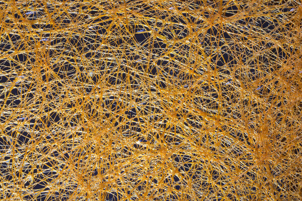 Абстрактный фон из желтых пластиковых нитей на темном фоне