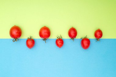 Still life with red ripe tomatoes on a colored background