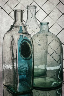 Gri arka planda şeffaf cam bir şişeyle