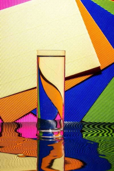 抽象的な色鮮やかな背景に水のガラスと静物画 — ストック写真