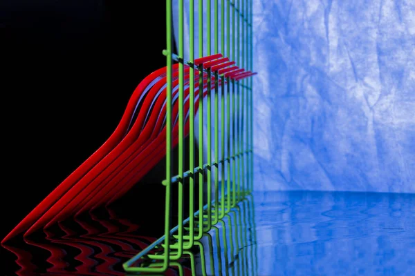 概要青い背景に赤いフォークと緑のフェンスで静物画 — ストック写真