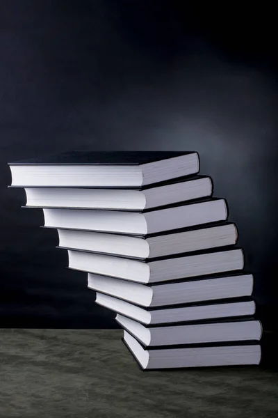 暗い背景に斜面で折り畳まれた本のスタック — ストック写真