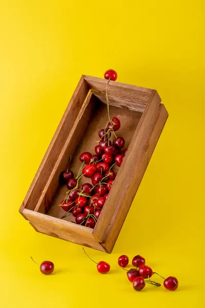 Natureza Morta Com Frutas Cereja Uma Caixa Madeira Fundo Amarelo — Fotografia de Stock