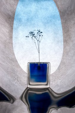 Yansıtıcı yüzeyde bir çiçek dalıyla sakin bir hayat