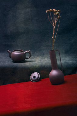 Still life with a vase of flowers and a kettle with a lid