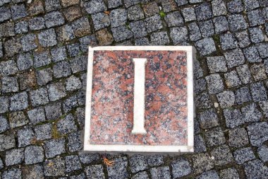 1 numaralı Roma rakamı taştan bir yolun arka planına karşı