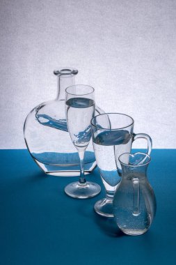 Masadaki gri-mavi arka planda cam eşyalar