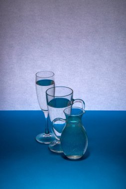 Masadaki gri-mavi arka planda cam eşyalar