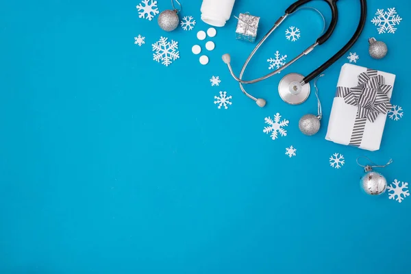 Noel, ilaç tebrik kartı. Boş pano, Noel süslemeleri, mavi arka planda haplar. Tıbbi konsept. Uzayı kopyala, düz yat