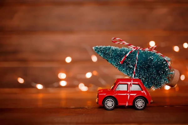 Juguete Coche Rojo Miniatura Entregando Árbol Navidad Sobre Fondo Madera —  Fotos de Stock