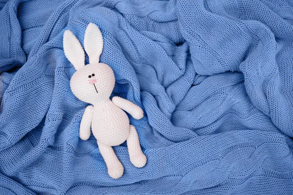 Pequeño Conejo Amigurumi Punto Bebé Está Una Manta Azul Puesta — Foto de Stock