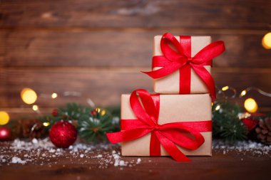 Noel tebrik kartı konsepti. Hediye kutusunda Noel ağacı ve tahta arka planda ışıklar var. Boşluğu kopyala.