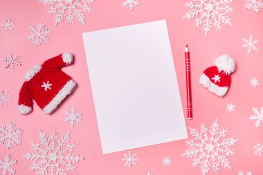 Pembe mercan arka planında noel süslemeleri olan kağıt boş. Yeni yıl çözünürlük kavramı telif alanı üst yatay görünümü. Üst manzara, düz yatış. Model.