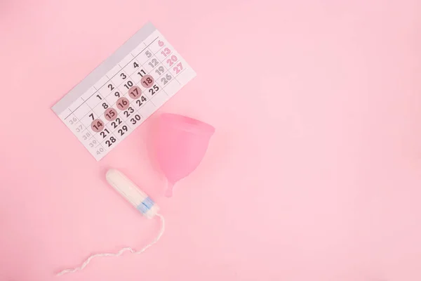 Tampon dan cangkir menstruasi dengan latar belakang merah muda. Konsep hari kritis, menstruasi. Tampilan atas, lay datar, ruang penyalinan — Stok Foto