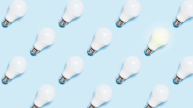 Yaratıcı stop hareketli animasyon. Mavi arka planda ışık saçan lambalar. Eko enerji kavramı ya da iş için beyin fırtınası.