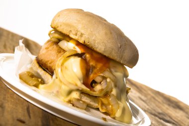 Biber sosu ve ahşap masa üzerinde soğan ile baharatlı kavrulmuş domuz topuz. Beyaz arka plan