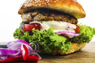 Ahşap masa üzerinde sebzeler ile lezzetli Hamburger