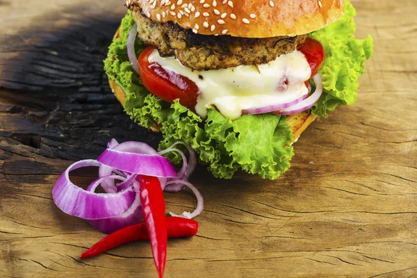 Yummy Hamburger with Veggies on Wooden Table — Stock Photo, Image