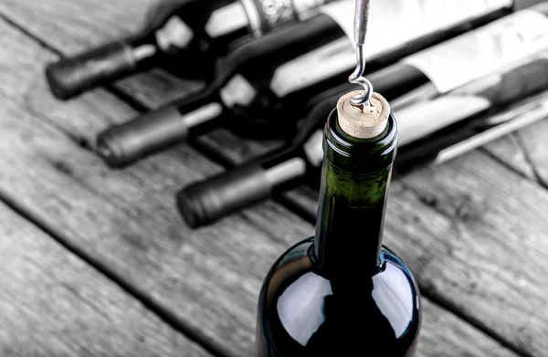 Wine bottle on a wooden table standing out from the crowd — Stock Photo, Image