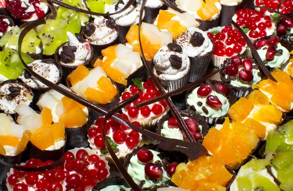 Leckere Miniaturkuchen mit Süßigkeiten am Buffet — Stockfoto