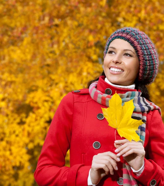 Mladá žena venku s podzimní listí — Stock fotografie