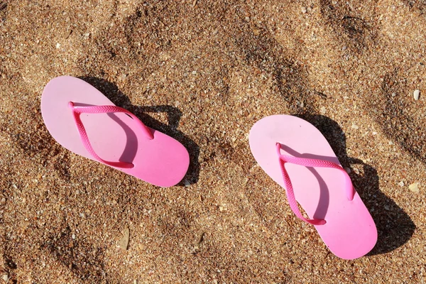 Tongs roses pour enfants sur le sable — Photo