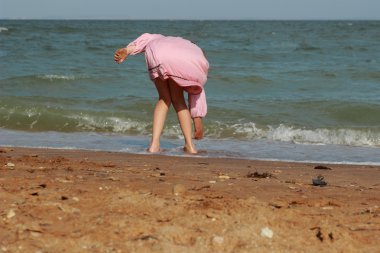 Doğu Kırım 'da deniz kıyısında oynayan güzel küçük bir kızın açık hava görüntüsü.