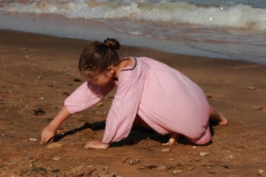 Doğu Kırım 'da deniz kıyısında oynayan güzel küçük bir kızın açık hava görüntüsü.