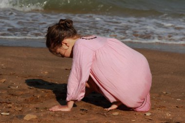 Doğu Kırım 'da deniz kıyısında oynayan güzel küçük bir kızın açık hava görüntüsü.