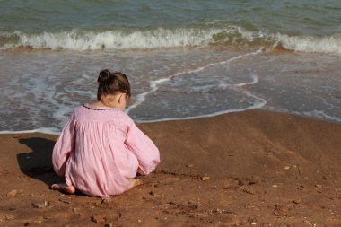 Doğu Kırım 'da deniz kıyısında oynayan güzel küçük bir kızın açık hava görüntüsü.