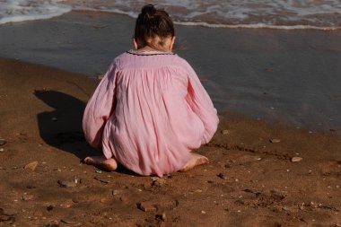 Doğu Kırım 'da deniz kıyısında oynayan güzel küçük bir kızın açık hava görüntüsü.