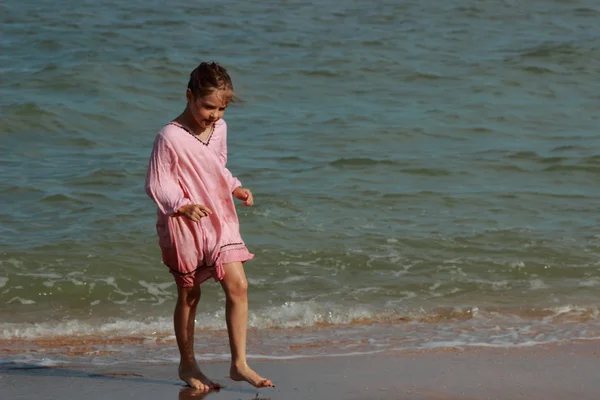 Красивая Маленькая Девочка Светло Розовом Платье Играет Галькой Над Морем — стоковое фото