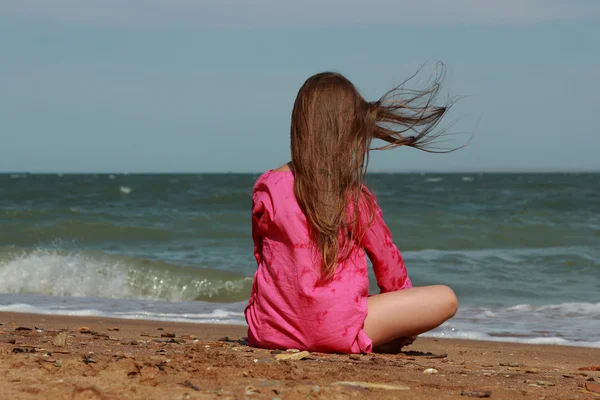 在阳光明媚的夏日 克里奇 小女孩背对着摄像机坐在海滩上 — 图库照片