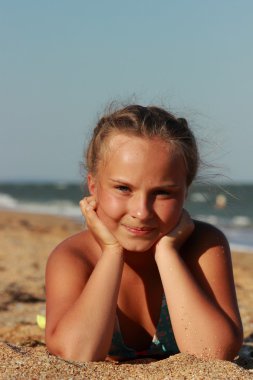 Yaz tatili, deniz suyu yakınında sahilde dinlenmiş güzel kız