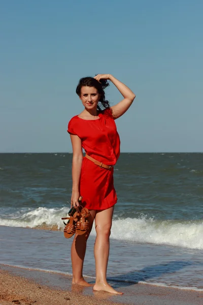 Kaunis nainen kävelee meren rannalla — kuvapankkivalokuva