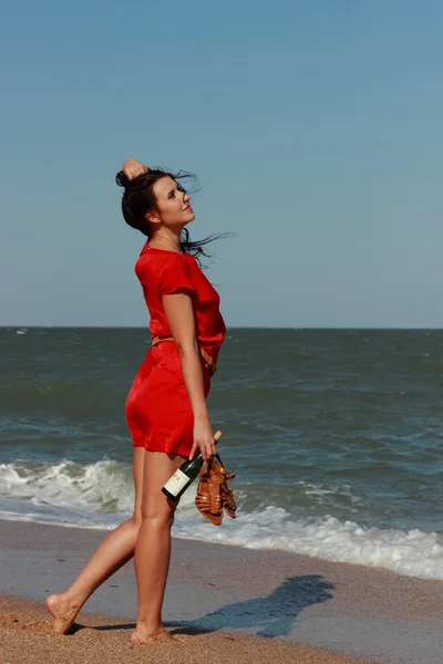 美丽的女人走在海的那边 湿红色的礼服 高跟鞋吧 — 图库照片