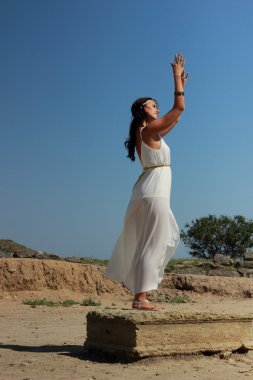 Antik kentin Nymphaeumu, köy geroevskoe, Kırım Cumhuriyeti kazılarda yürüyen Yunan tarzı bir beyaz uzun tunik uzun siyah saçlı çekici genç kız