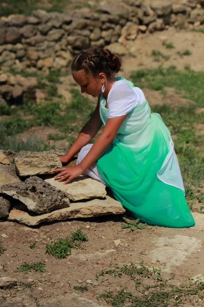 ギリシャのチュニックで魅力的な笑顔の若い女の子は 村Geroevskoeのニンファウムの古代都市の遺跡の背景にオリーブの小枝を保持しています ケルチ — ストック写真