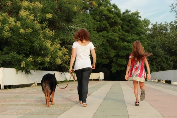 Mor och dotter leker med hund — Stockfoto