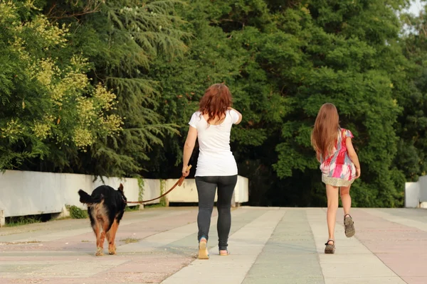 Mor och dotter leker med hund — Stockfoto