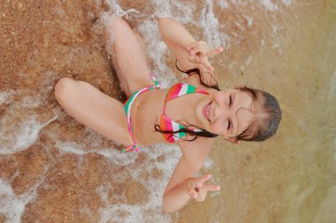 Parlak bir mayo mutlu sevimli küçük kız oynamak ve eğlenmek vasıl belgili tanımlık kıyı tatil ve yaz tatil