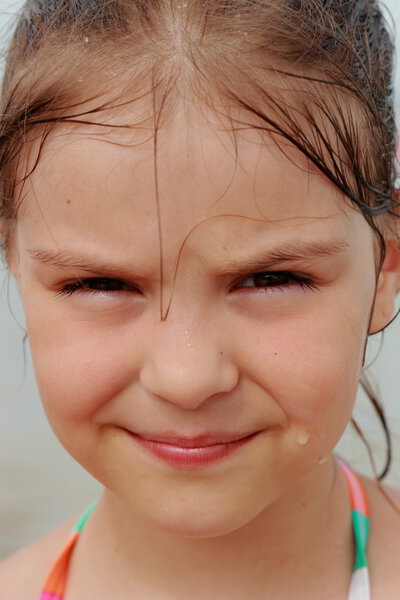 Happy cute little girl in a bright swimsuit play and have fun at the beach on holiday and summer vacation